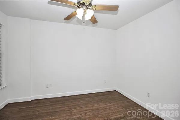 a view of a room with wooden floor and a ceiling fan