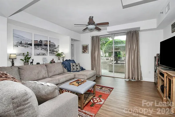 a living room with furniture a flat screen tv and a floor to ceiling window