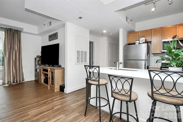 a view of a dining room with furniture a kitchen and chandelier