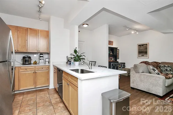 a kitchen with stainless steel appliances kitchen island granite countertop a sink and a refrigerator