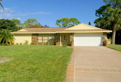 1683 Northwest Spruce Ridge Drive Stuart, FL 34994 - Photo 1 of 23 a front view of a house with a yard