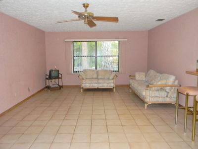 1683 Northwest Spruce Ridge Drive Stuart, FL 34994 - Photo 16 of 23 a living room with a baby crib furniture and a window
