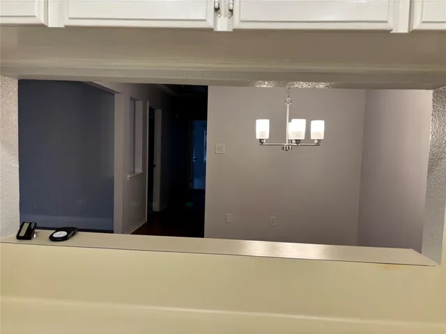 a backyard of a house with plants and large tree