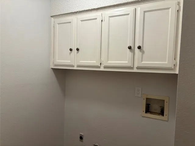 a view of a backyard with large trees and wooden fence