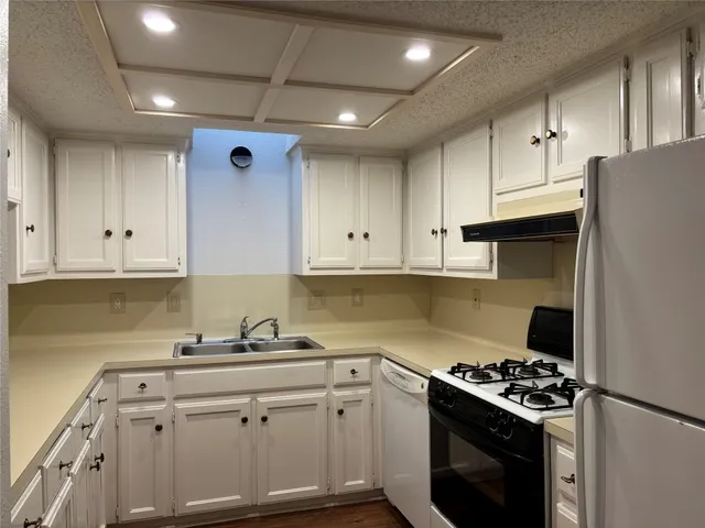 a kitchen with cabinets appliances a sink and a counter top space