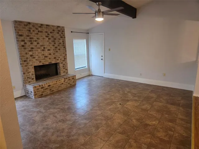 an empty room with a fireplace and window