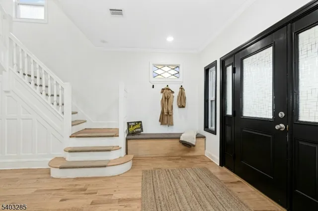 a view of entryway and hall with wooden floor