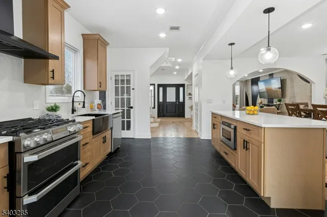 a large kitchen with stainless steel appliances granite countertop a stove and a sink