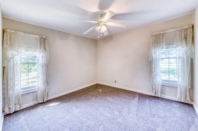an empty room with a ceiling fan and a chandelier fan