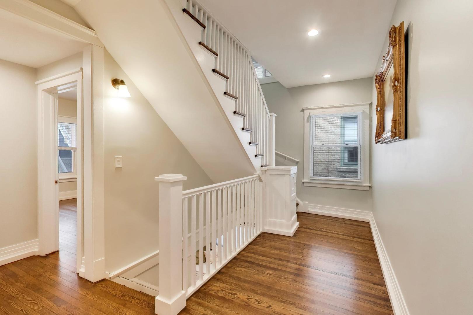7015 North Sheridan Road Chicago, IL 60626 - Photo 13 of 40 a view of a hallway with wooden floor and staircase