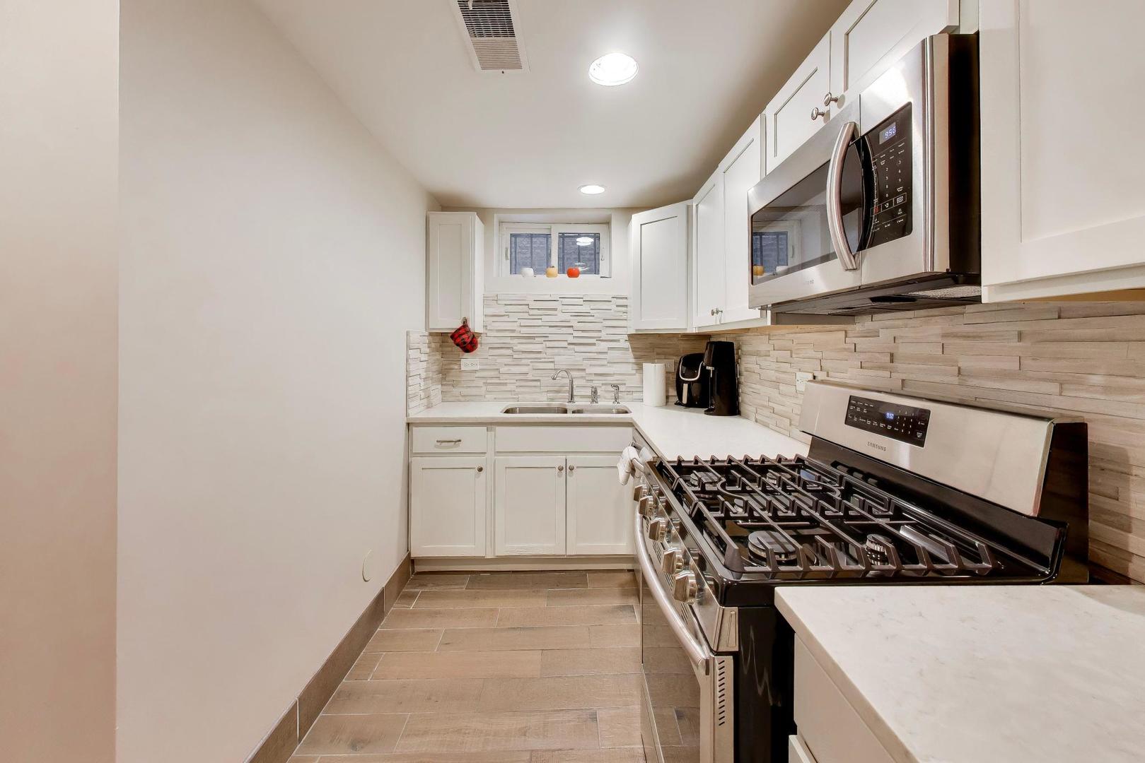 7015 North Sheridan Road Chicago, IL 60626 - Photo 24 of 40 a kitchen with stainless steel appliances a sink stove and cabinets