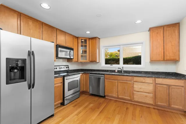 a kitchen with granite countertop stainless steel appliances a sink cabinets and a counter top space