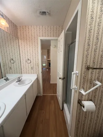a bathroom with a sink a mirror and a shower
