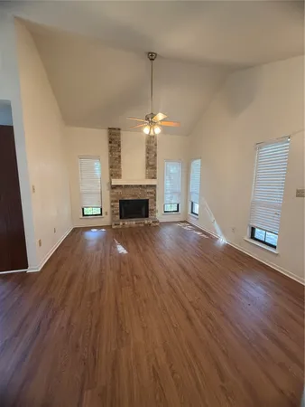a view of empty room with wooden floor and fireplace