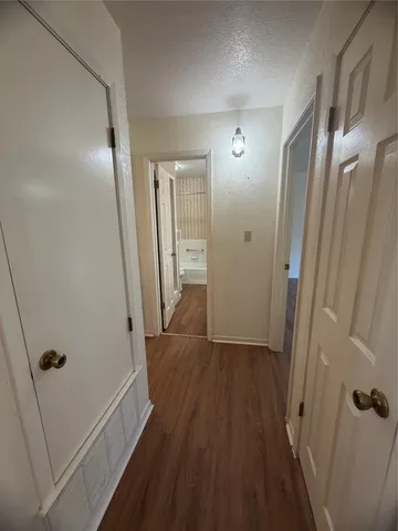 a view of a hallway with wooden floor