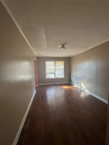 an empty room with windows and hardwood floor