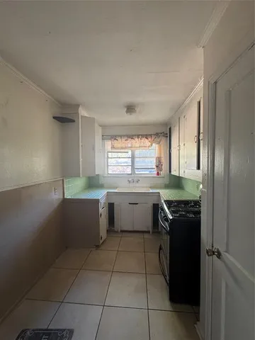 a kitchen with a sink a stove and cabinets