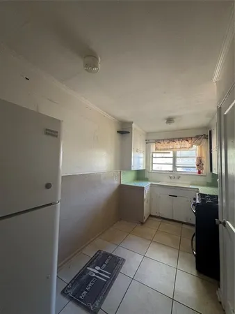a kitchen with granite countertop a refrigerator and a sink