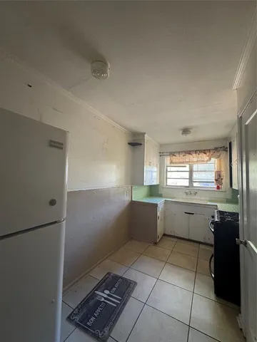 a kitchen with granite countertop a refrigerator and a sink