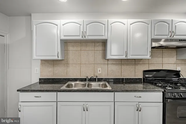 a kitchen with granite countertop a stove and a refrigerator