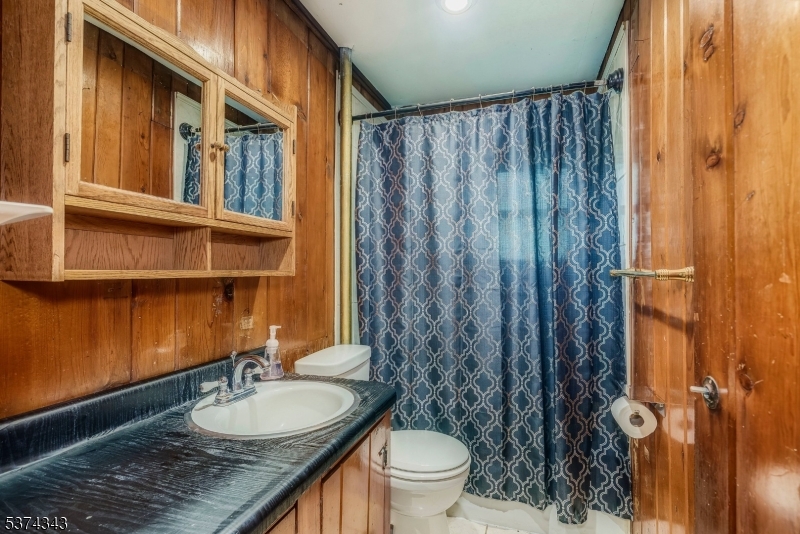 114 Pocantecs Road Vernon, NJ 07422 - Photo 12 of 20 a bathroom with a granite countertop sink and a mirror