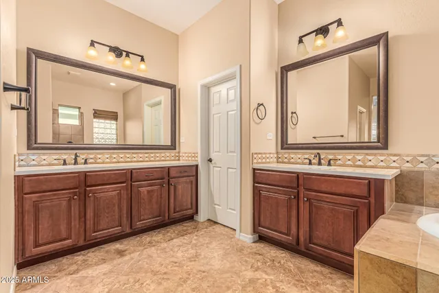 a spacious bathroom with a tub sink and mirror