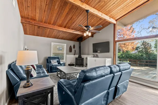 a living room with furniture a flat screen tv and a floor to ceiling window