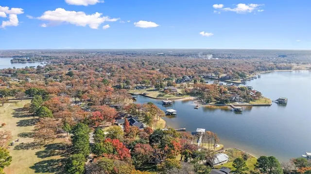 an aerial view of ocean and residential houses with outdoor space