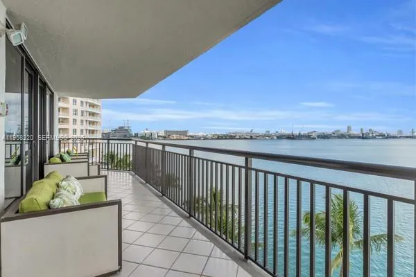 a view of a balcony with wooden chairs and city view