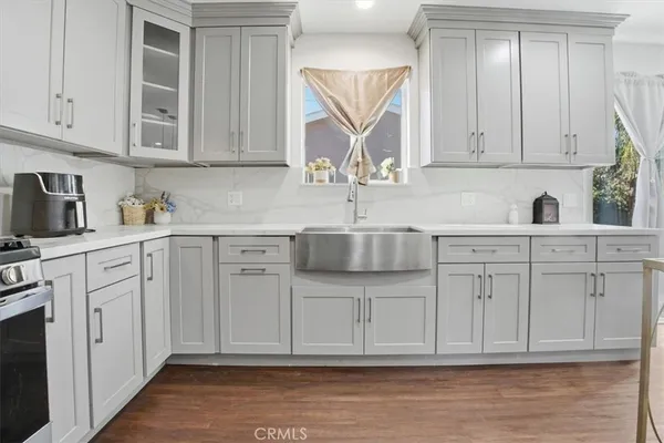 a kitchen with white cabinets and sink
