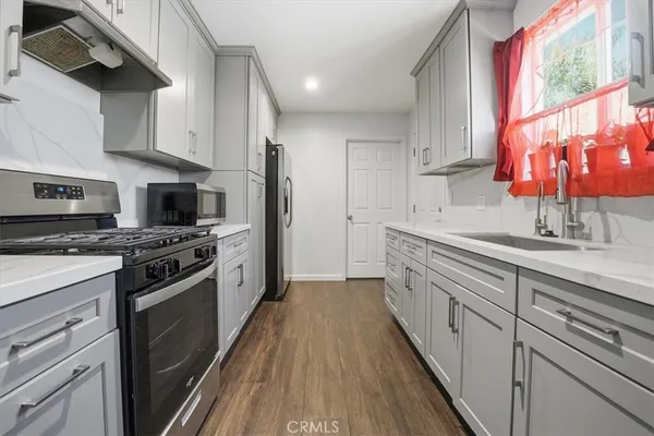 a kitchen with stainless steel appliances a sink dishwasher a stove and a refrigerator
