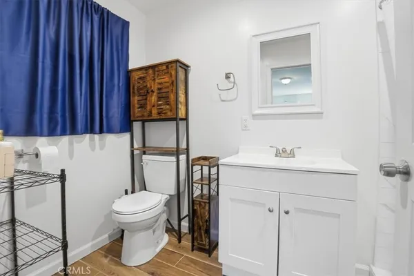 a bathroom with a toilet sink vanity and mirror