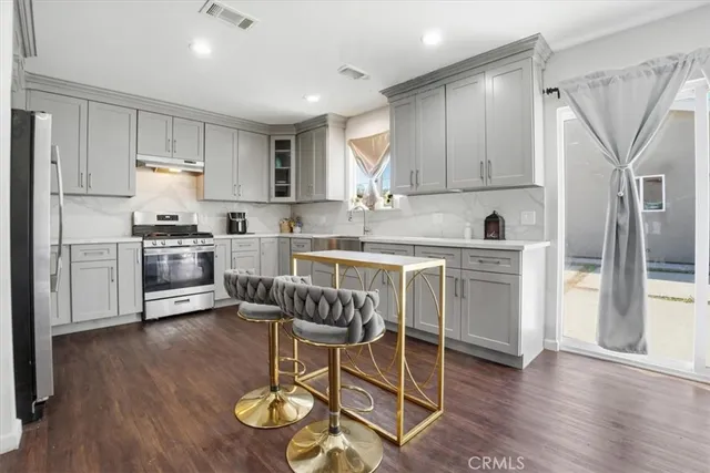 a kitchen with stainless steel appliances granite countertop a sink and a refrigerator