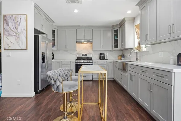a kitchen with stainless steel appliances white cabinets and wooden floors