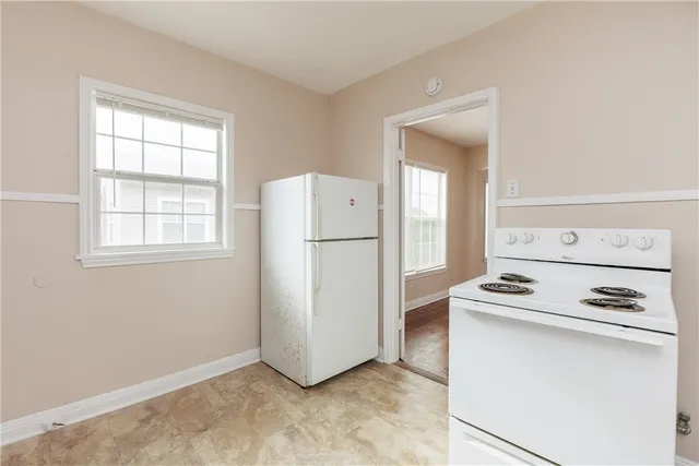a kitchen with a refrigerator and white stove top oven