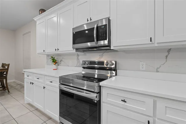 a kitchen with stainless steel appliances white cabinets and a stove a oven
