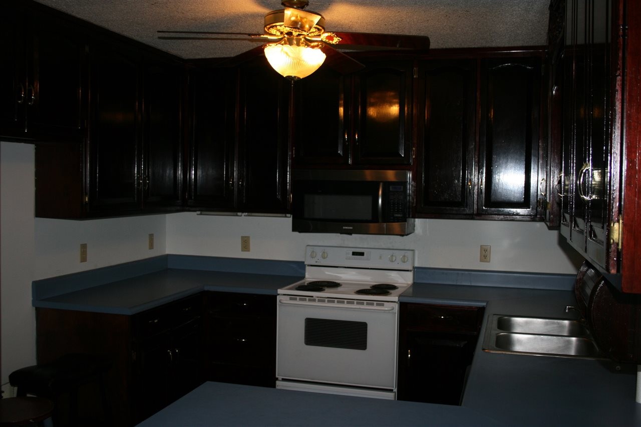 400 Dean Drive Northwest Georgetown, TN 37336 - Photo 6 of 38 a kitchen with stainless steel appliances a stove and a microwave