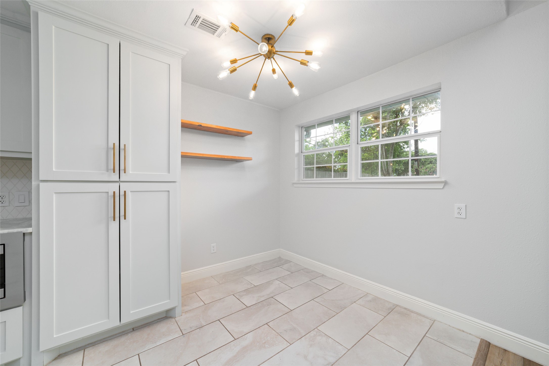 5922 Hummingbird Street Houston, TX 77096 - Photo 13 of 26 Who says breakfast has to be rushed? Natural light pours through energy-efficient double-pane windows, while custom shelving adds the perfect place to style your favorite pottery, cookbooks, or growing plant collection.