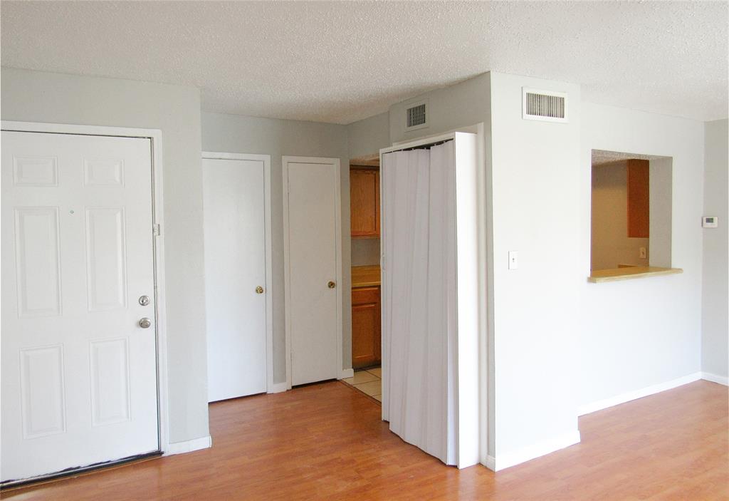 7431 Holly Hill Drive, Unit 216 Dallas, TX 75231 - Photo 7 of 19 a view of hallway with closet and wooden floor
