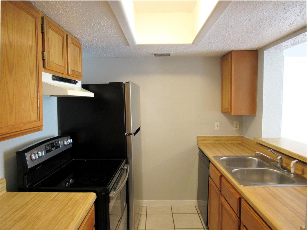7431 Holly Hill Drive, Unit 216 Dallas, TX 75231 - Photo 8 of 19 a kitchen with a sink stove and refrigerator