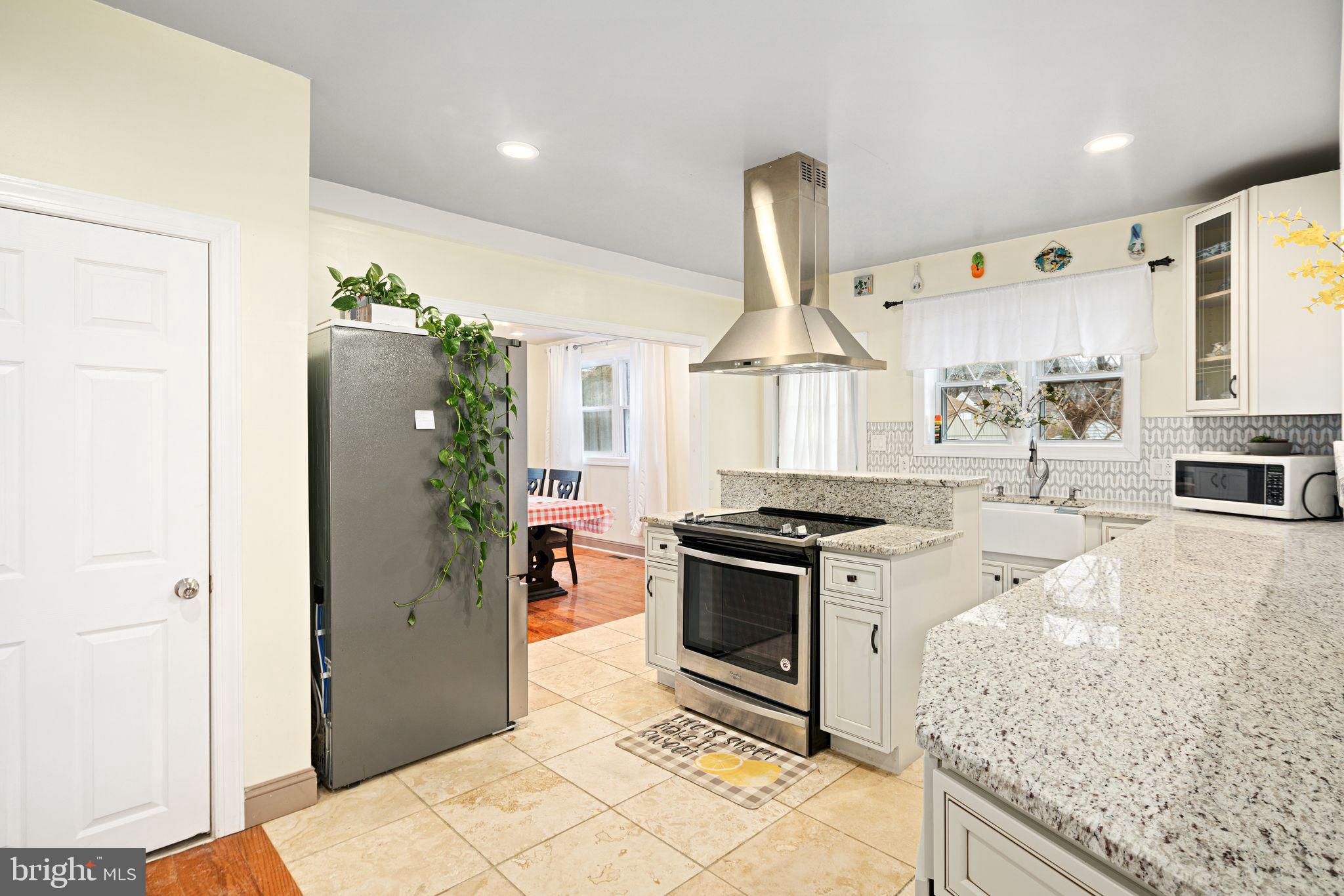1034 Excelsior Drive Upper Chichester, PA 19014 - Photo 7 of 33 a kitchen with stainless steel appliances granite countertop a stove a sink and a refrigerator