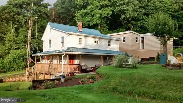 a front view of a house with a garden and trees