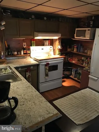 a kitchen with stainless steel appliances granite countertop a sink and a stove