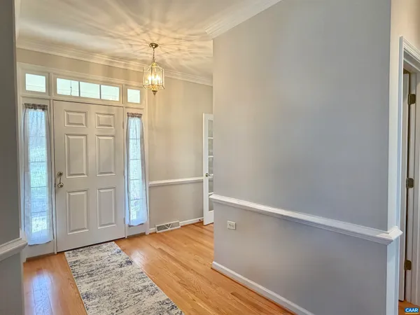 an empty room with wooden floor cabinet and windows