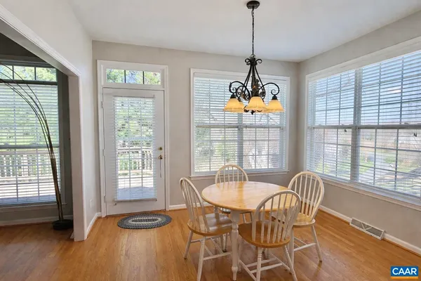 a dining room with furniture a chandelier and wooden floor