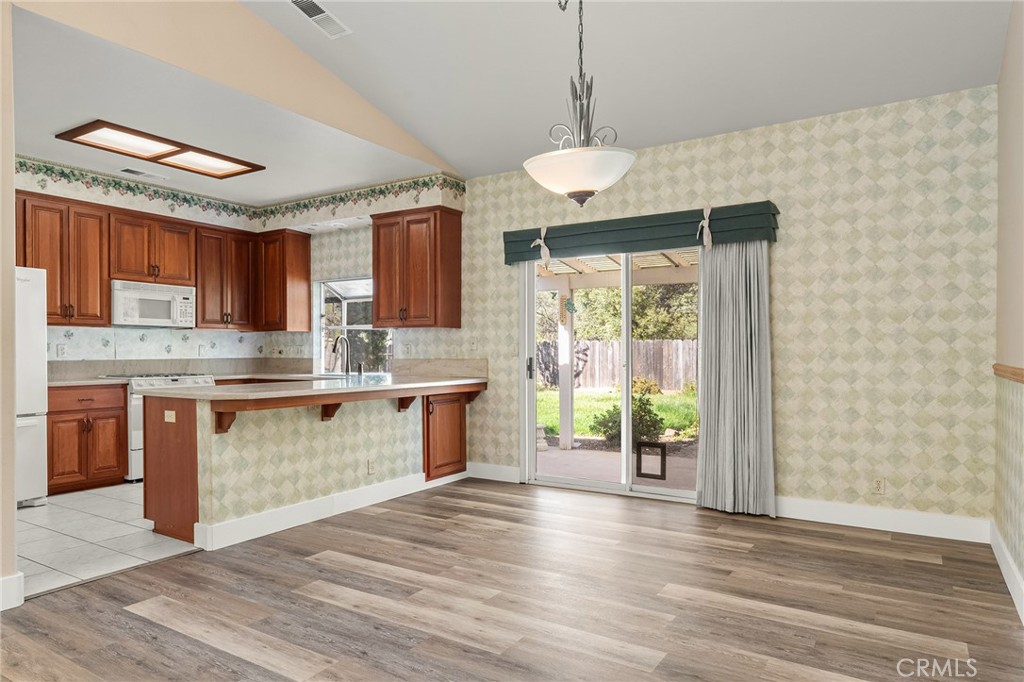 378 Picholine Way Chico, CA 95928 - Photo 12 of 52 a kitchen with stainless steel appliances granite countertop a stove top oven a refrigerator a sink and dishwasher with wooden floor
