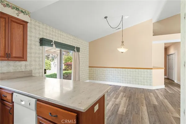 a view of a hallway with wooden floor and a bathroom