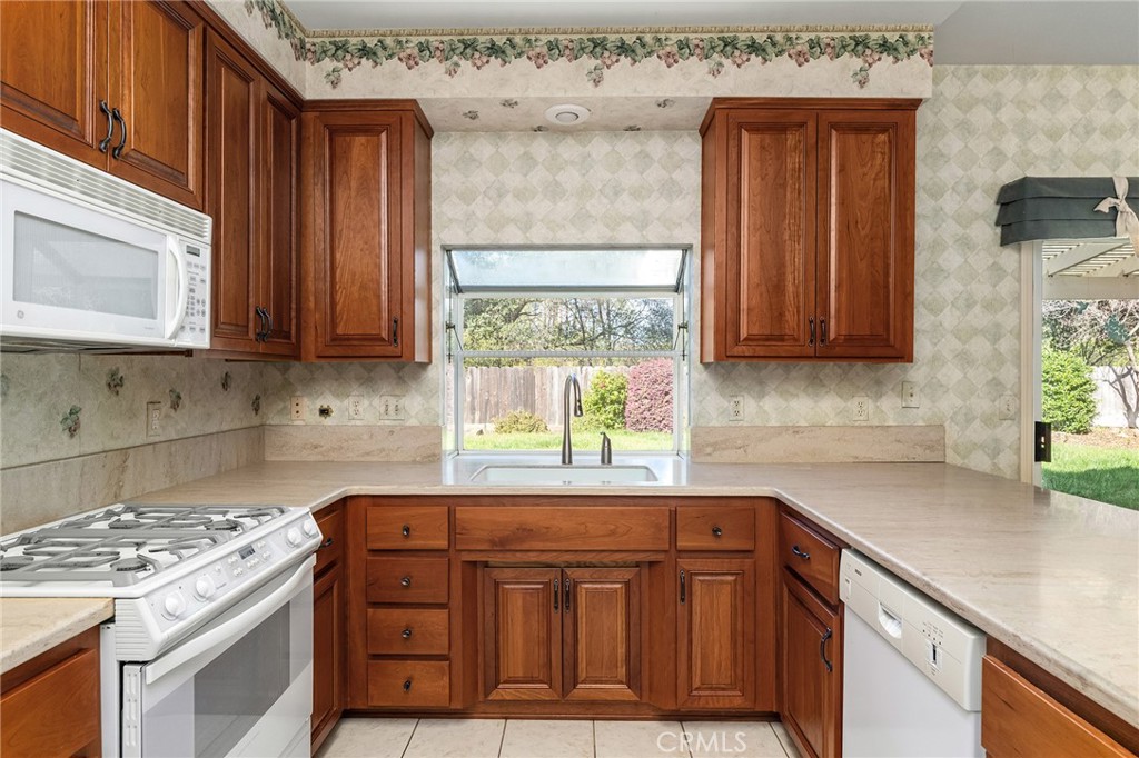 378 Picholine Way Chico, CA 95928 - Photo 14 of 52 a kitchen with stainless steel appliances granite countertop wooden cabinets a stove a sink and a window
