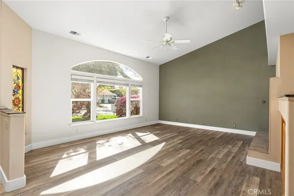 a view of empty room with fireplace and wooden floor