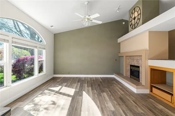 a view of a livingroom with wooden floor and a fireplace